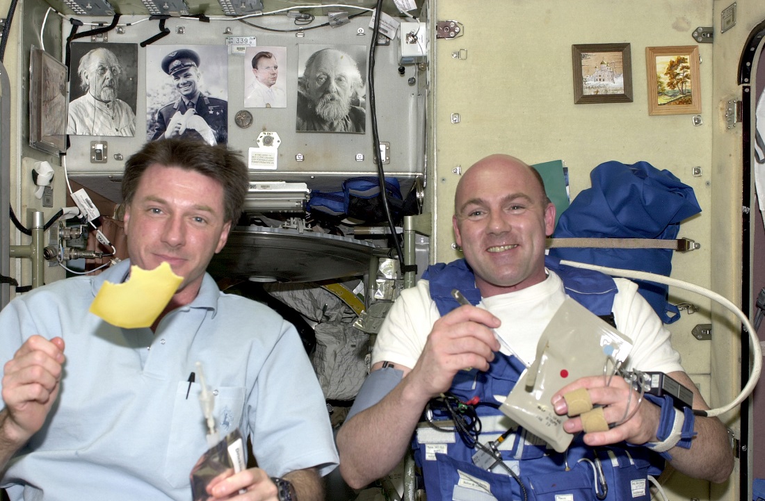 So kann zum Beispiel ein Frühstück im Weltraum aussehen: ESA Astronauten André Kuipers und der NASA-Kollege Michael Foale essen Käse. (Foto: dpa)
