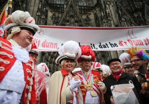 Die Kölner Oberbürgermeisterin Henriette Reker (M) geht am 04.02.2016 in Köln (Nordrhein-Westfalen) zusammen mit Mitgliedern der den Karnevalsgesellschaft "Rote Funken" und dem Dompropst Gerd Büchner (2.v.r.) um den Dom vor Wildpinklern zu schützen. (Foto: dpa)