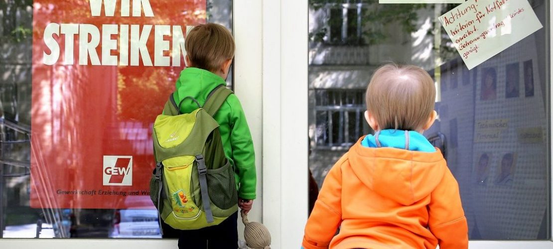 Zwei kleine Kinder stehen am 18.05.2015 an der Tür eines wegen Streik geschlossenen Kindergartens in Leipzig (Sachsen).