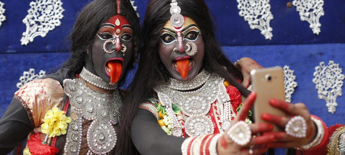 13.02.2018, Indien, Allahabad: Zwei als Hindu-Gottheit Kali verkleidete Jugendliche machen im Rahmen des Shivaratri Festivals ein Selfie.