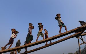 Myanmar, Rangun: Kinder entladen ein Schiff über wackelige Planken. (Foto: dpa)