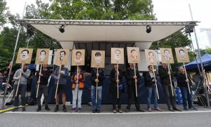 Vor dem Oberlandesgericht demonstrierten vor der Urteilsverkündung viele Menschen. Diese halten Schilder mit Abbildung der NSU-Opfer hoch. Foto: Tobias Hase/dpa